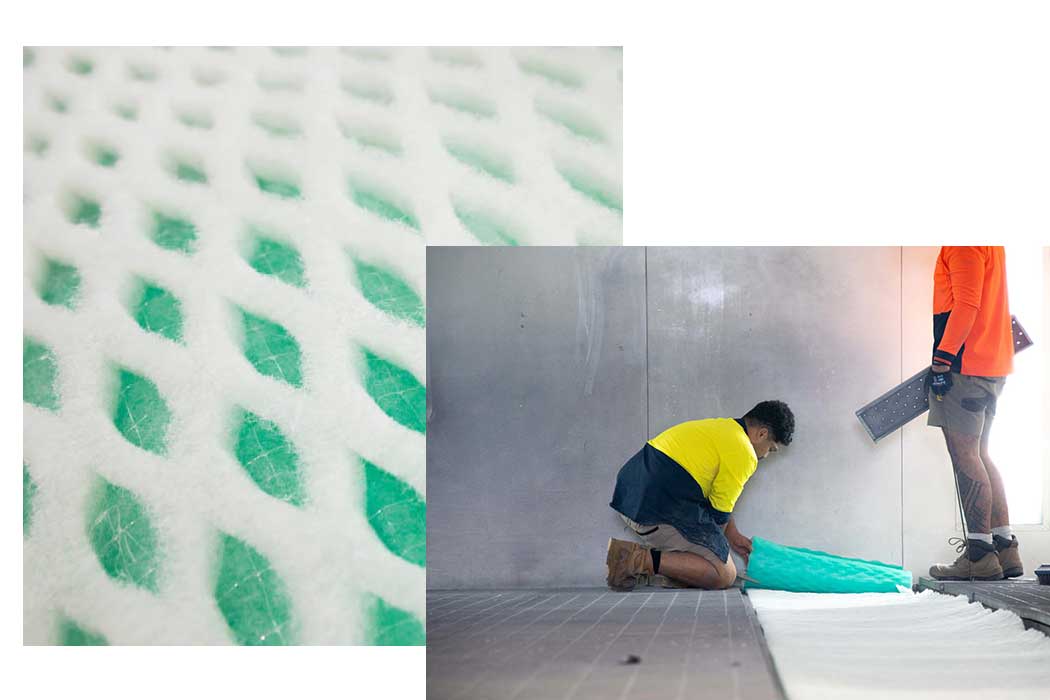 Close up of pocket style spray booth exhaust filter media beside a technician rolling fresh exhaust media into a spray booth floor