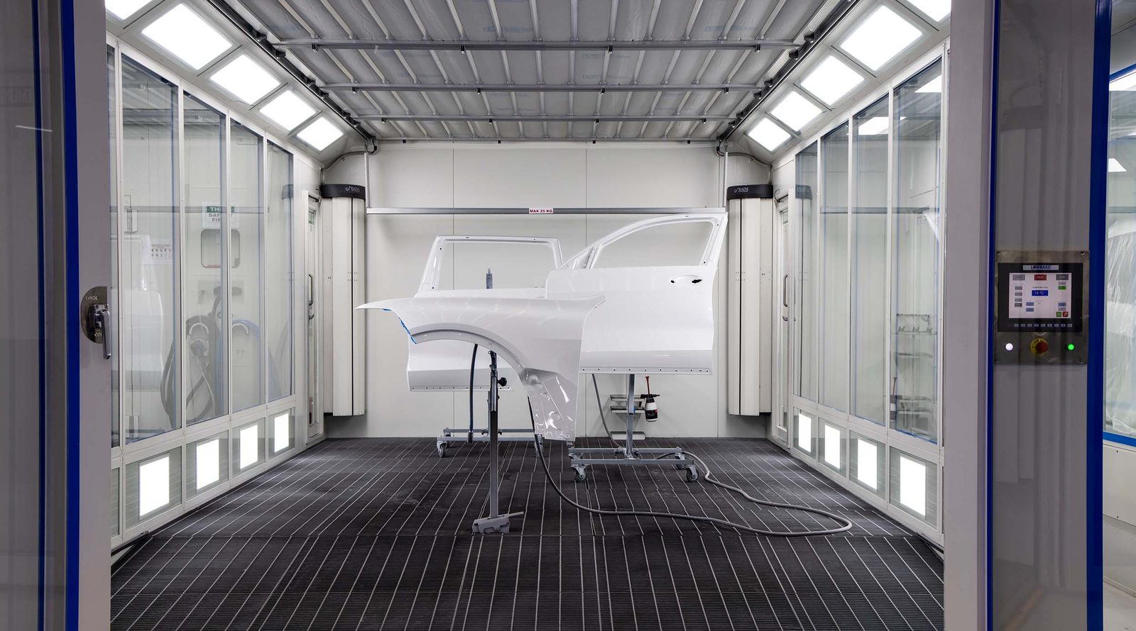 Clean, well lit spray paint booth with car doors on stands, ready for painting after a service